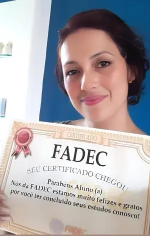 Aluna da FADEC segurando seu cartão de conclusão