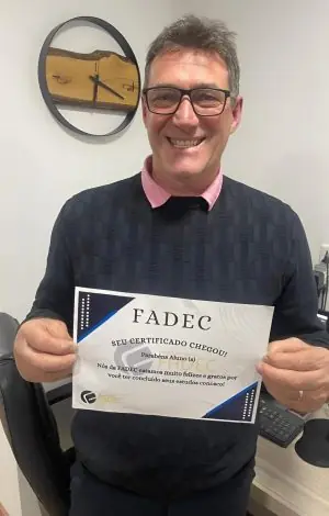 Aluno da FADEC com seu cartão de conclusão